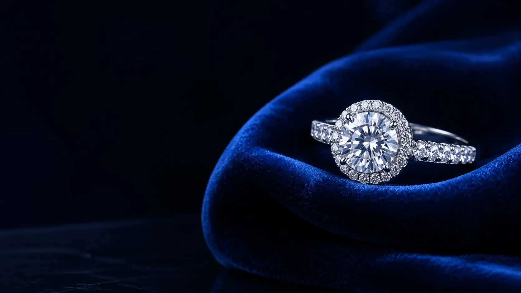 Diamond engagement ring resting on royal blue velvet